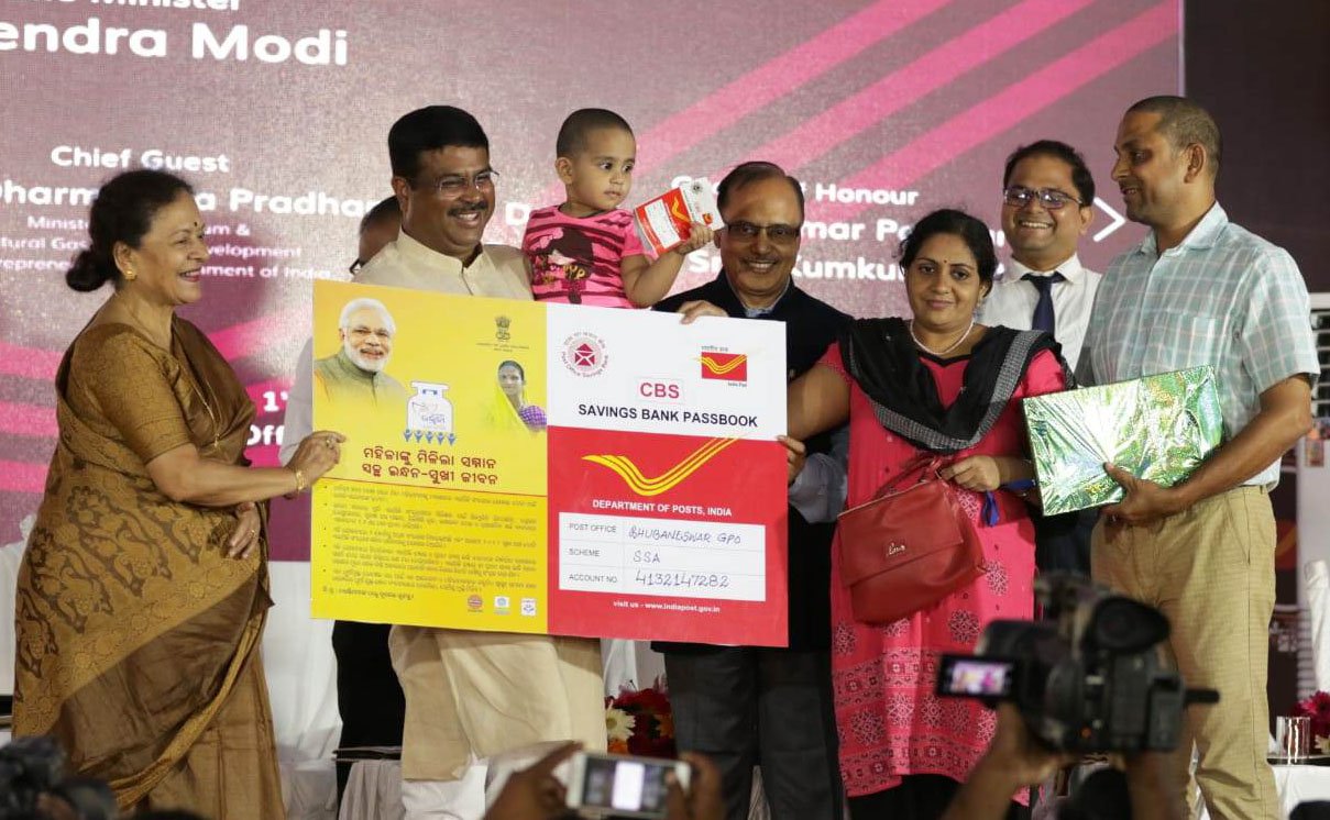 Indian child receiving a savings account passbook from a government banking programme