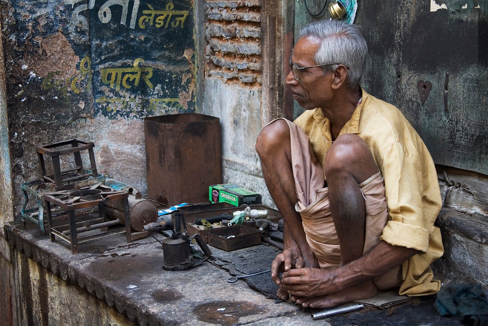 Indian small workshop owner working in a street-side enterprise, illustrating PMEGP self-employment opportunities