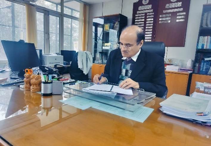 Indian government finance officer reviewing official documents at an office desk