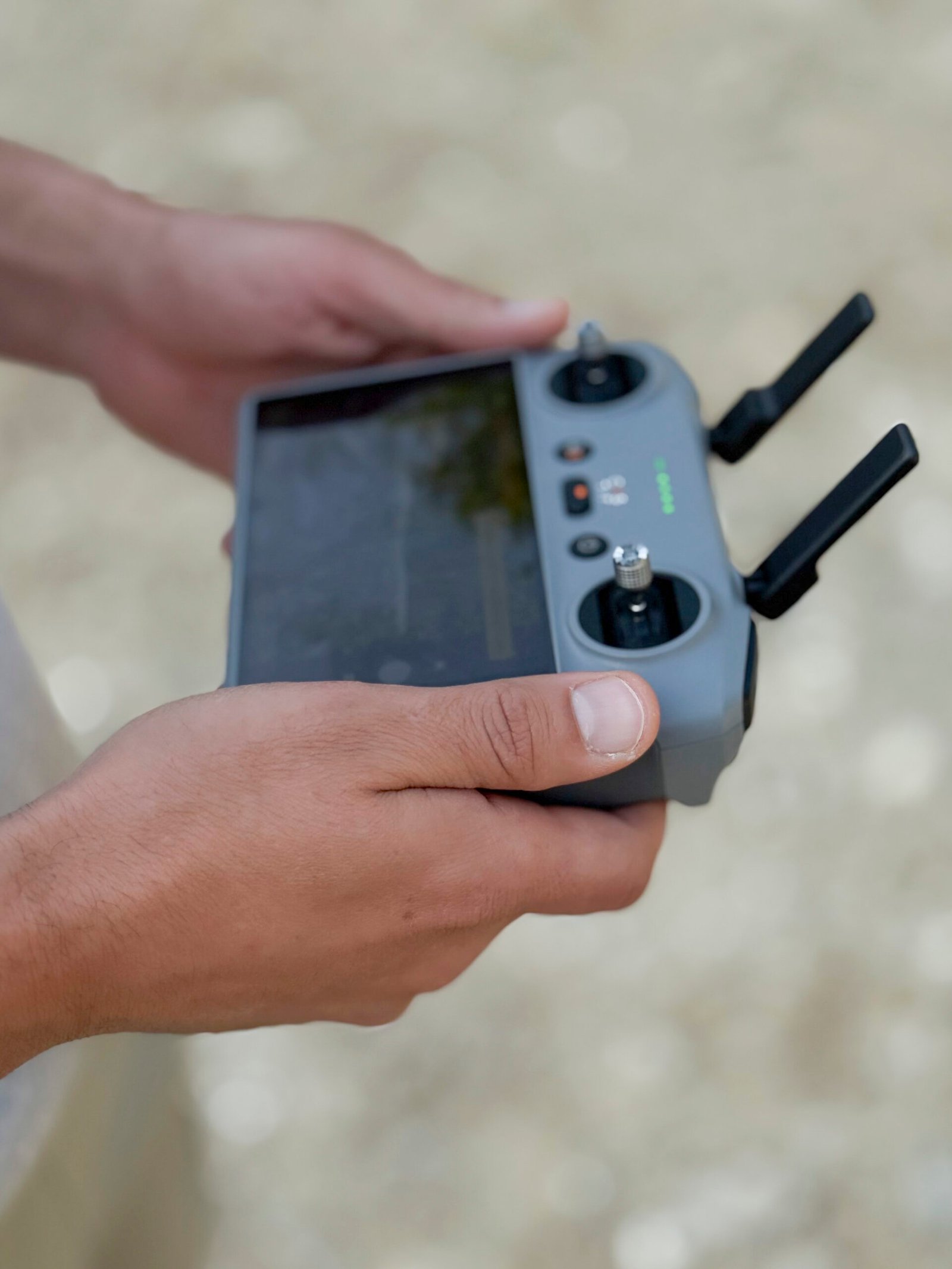 Person holding a drone remote control outdoors